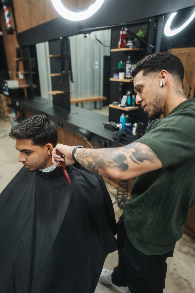 Tulio Barber cutting hair at Capitano Barbershop